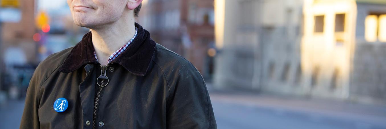 henkilöllä tumma takki, johon kiinnitetty näkövammaismerkki